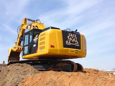Yellow excavator on a graded dirt site